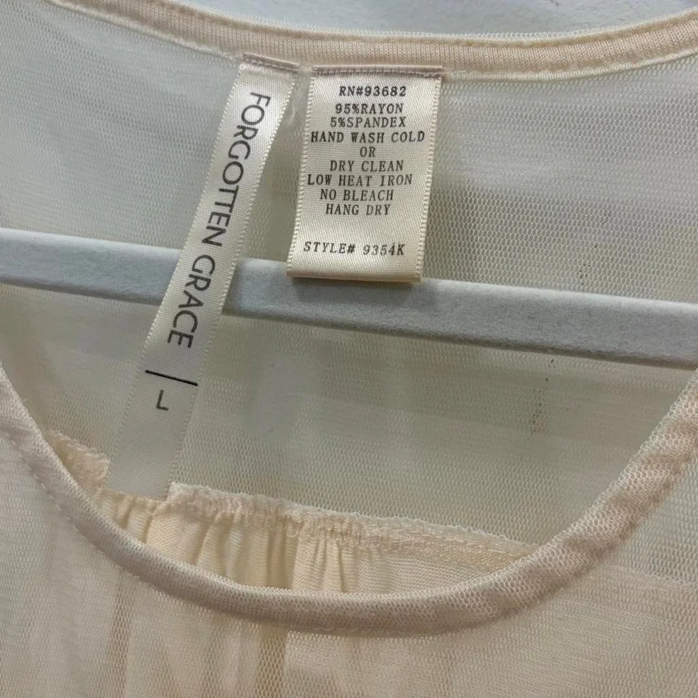 Cream lace tank top with sheer mesh and lace trim on the shoulders